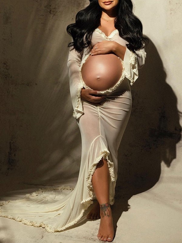 Ivory sheer maternity maxi dress with ruffle cut out crop design, deep V-neck, slit detail, and mermaid silhouette, designed for photoshoot.