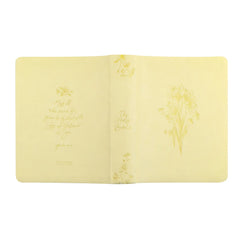 Open yellow Bible with floral designs and scripture on a white background