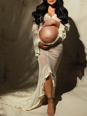 Ivory sheer maternity maxi dress with ruffle cut out crop design, deep V-neck, slit detail, and mermaid silhouette, designed for photoshoot.